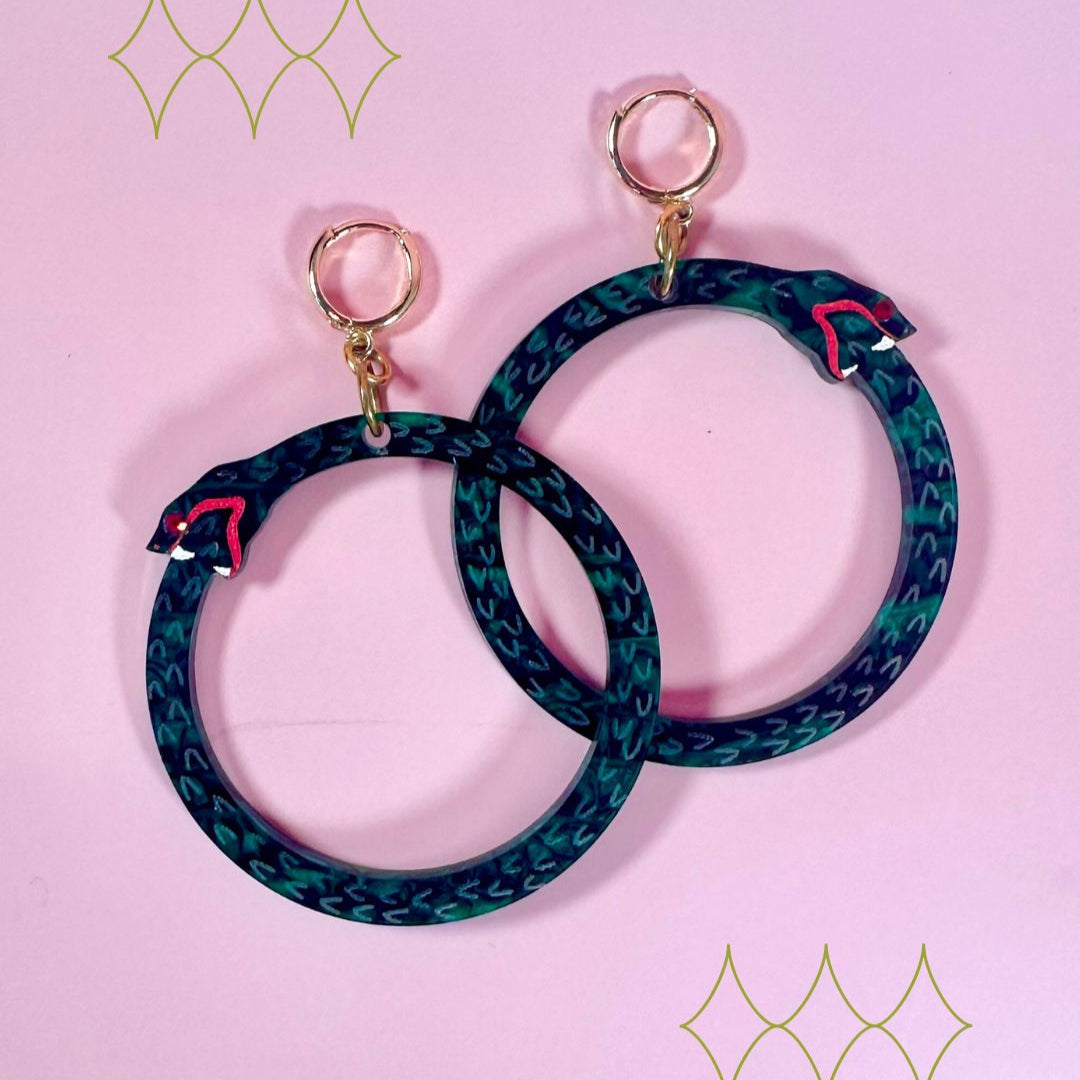 Pair of hoop earrings with blue and green pattern on a pink background
