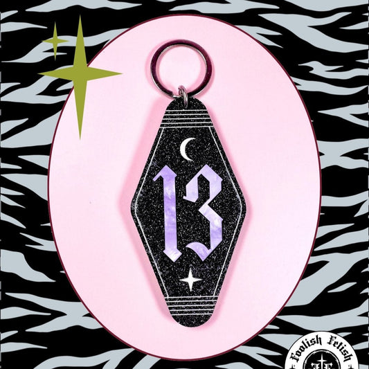 Keychain with number 13 on a pink background with zebra pattern