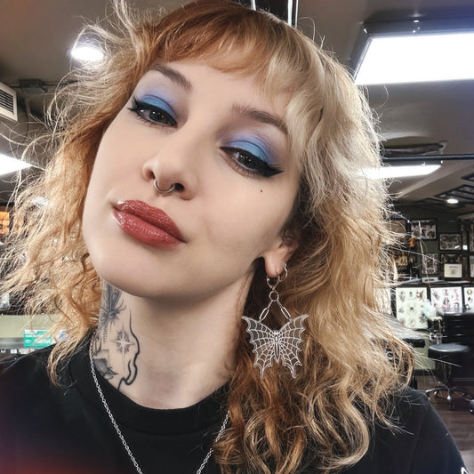 Person with styled hair and makeup in a casual indoor setting