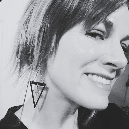 Black and white close-up of a person wearing a triangular earring.