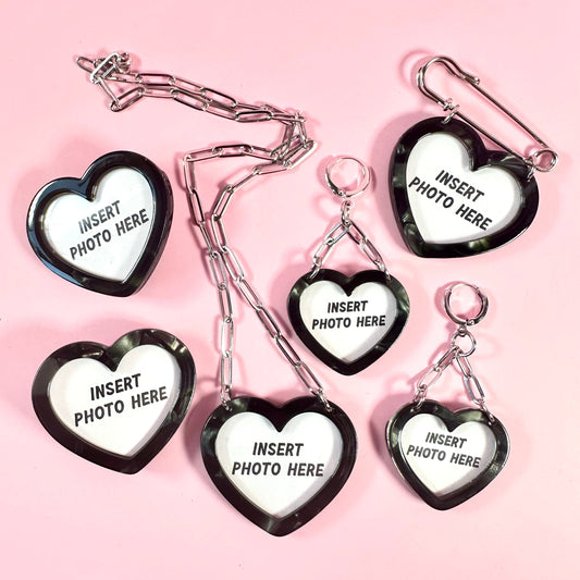 Heart-shaped photo holders with 'insert photo here' text on a pink background