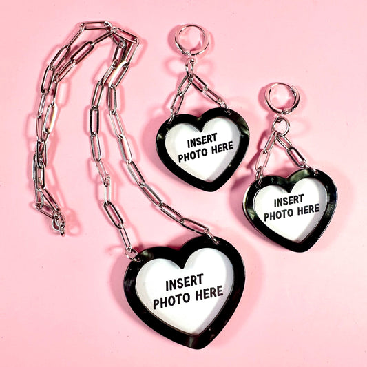Heart-shaped photo holders with chains on a pink background