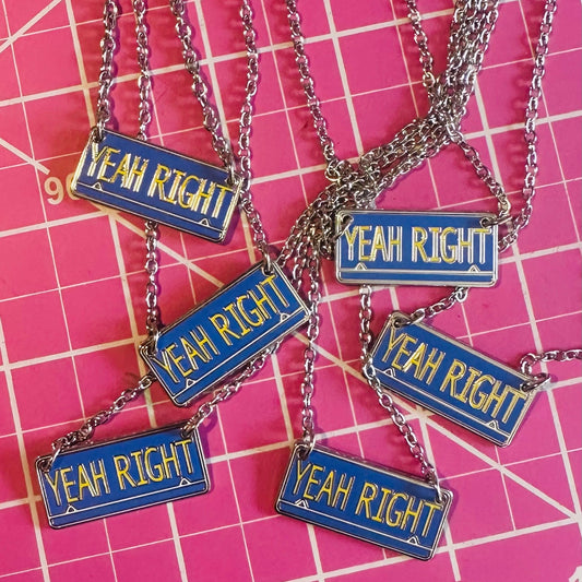 Necklaces with 'YEAH RIGHT!' pendants on a pink grid background
