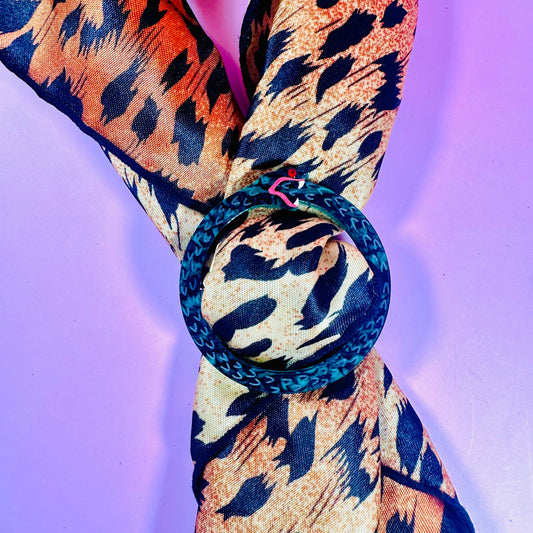 Leopard print scarf with a blue ring on a purple background