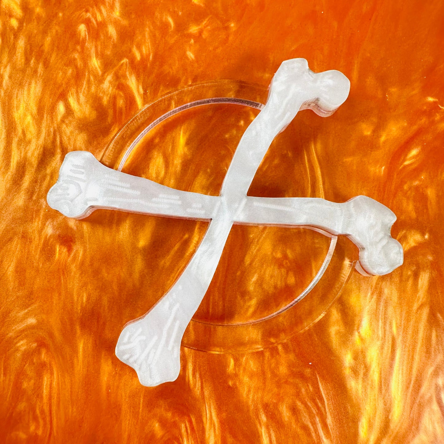 Clear glass with white bone-shaped decorations on an orange background