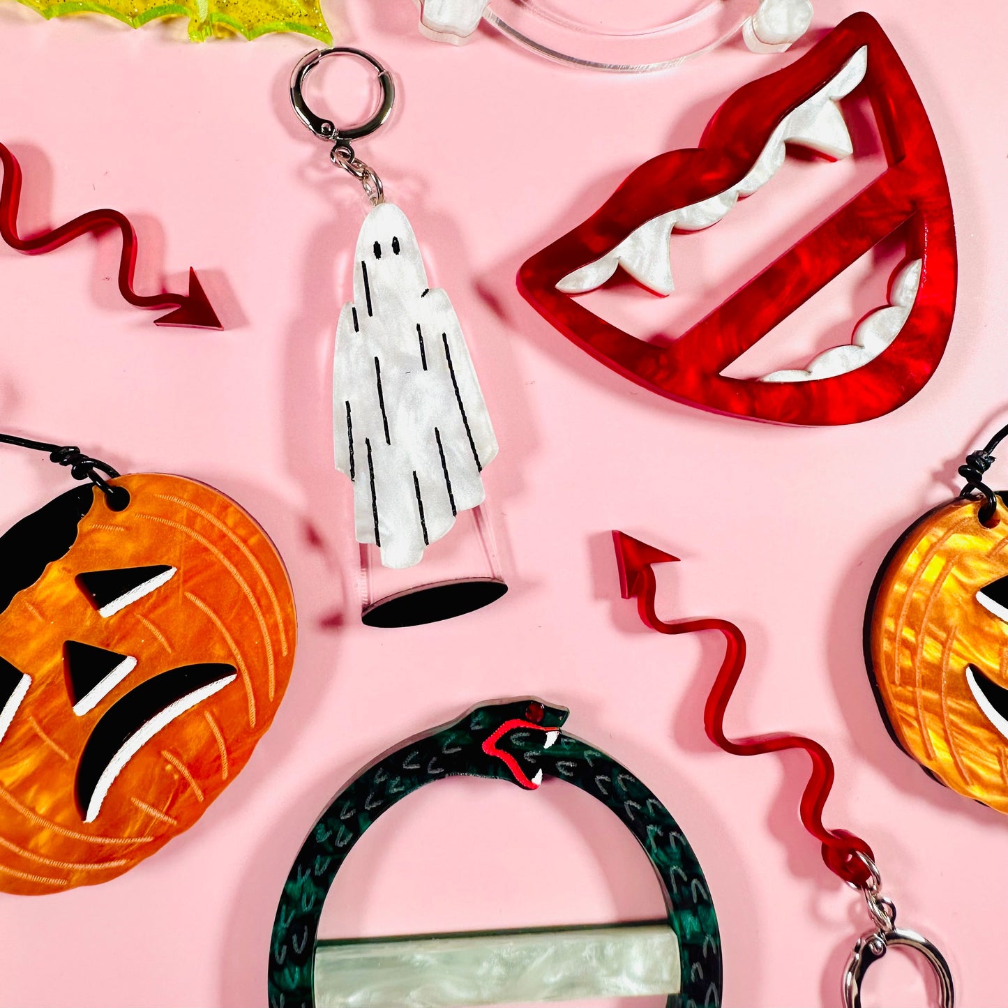 Collection of Halloween-themed keychains on a pink background