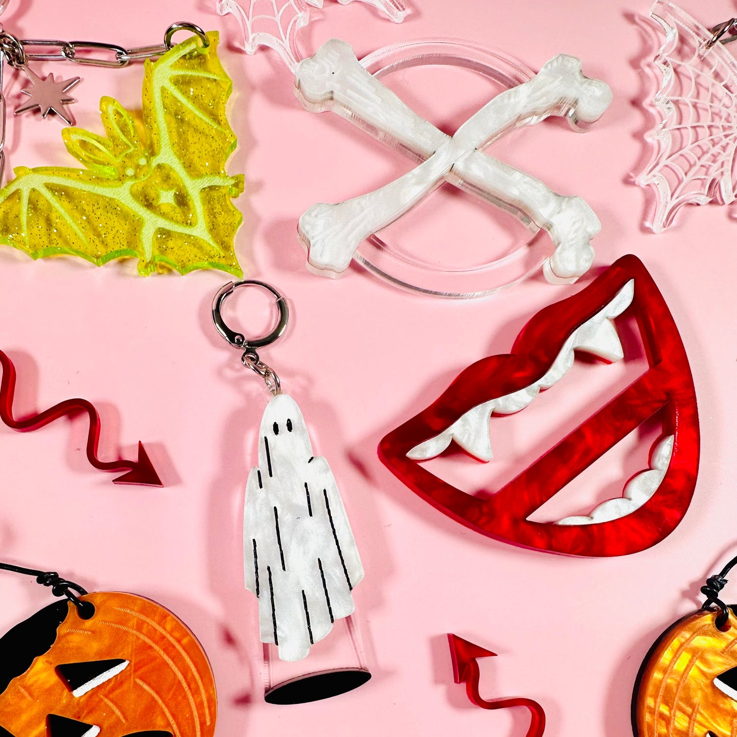 Collection of Halloween-themed keychains on a pink background