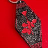 Keychain with red floral design on a black background against a red background