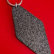 Black textured keychain on a red background