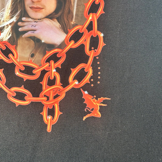 Artistic depiction of a person lying down with chains and a small figure on a dark background