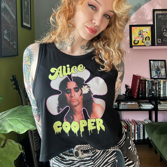 Person wearing a tank top with Alice Cooper design in a room with books and decor.