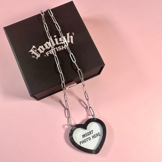 Heart-shaped photo frame pendant with 'English Fetish' branding on a pink background