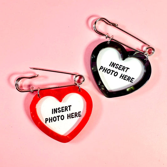 Two heart-shaped photo frames with 'Insert Photo Here' text on a pink background