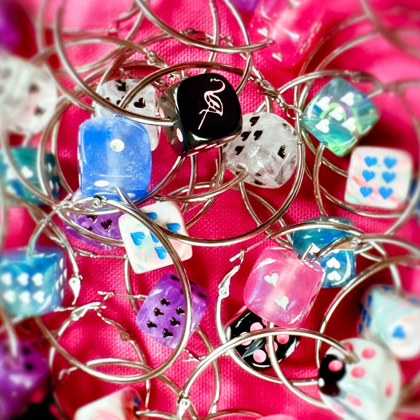 Close-up of colorful dice-shaped charms on a pink background