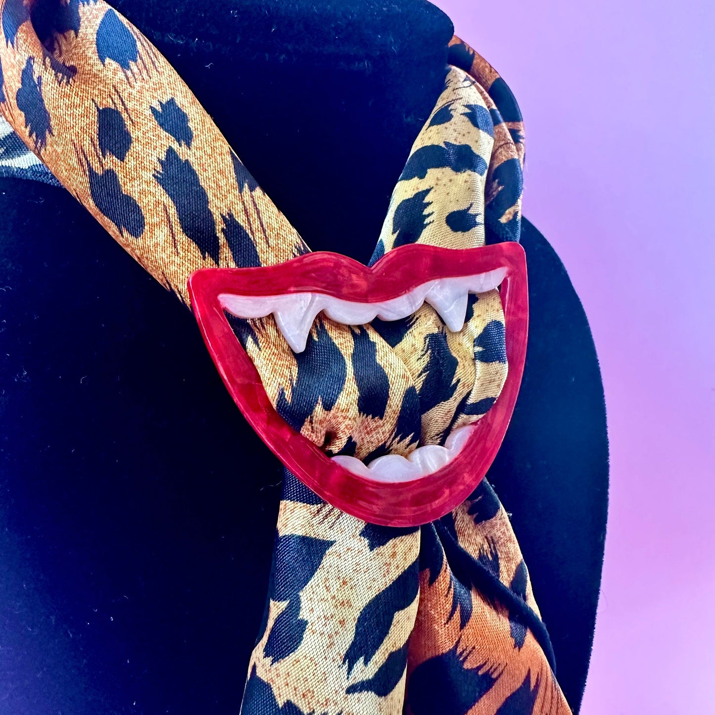 scarf ring of a red open mouth with white fangs on a leopard print scarf