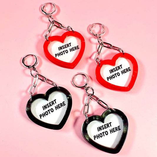 Four heart-shaped keychains with 'Insert Photo Here' text on a pink background