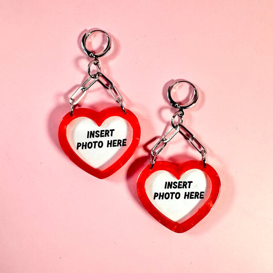 Heart-shaped keychains with 'Insert photo here' text on a pink background