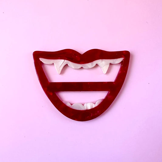 red mouth with fang scarf ring buckle on pink background