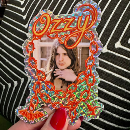 Holographic 'Ozzy' mirror with a person's reflection held by a hand.