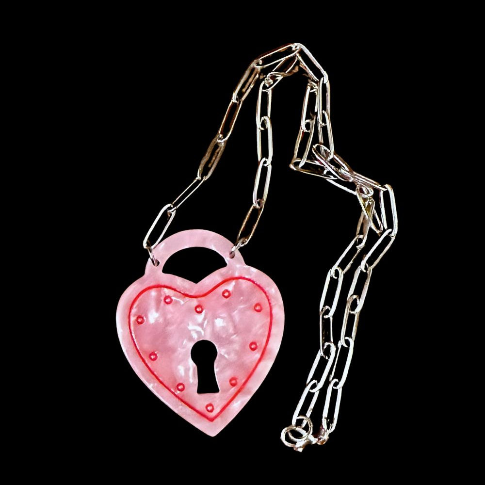 Pink heart-shaped padlock with chain on a black background