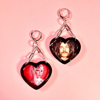 Heart-shaped earrings with images of a man and a woman on a pink background