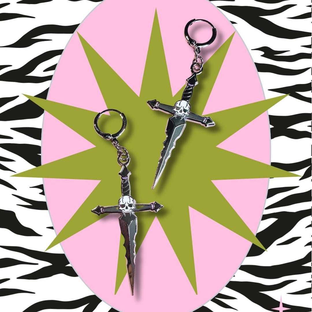 Gothic punk alternative Dagger-shaped earrings on a pink and green star-shaped card with zebra pattern background