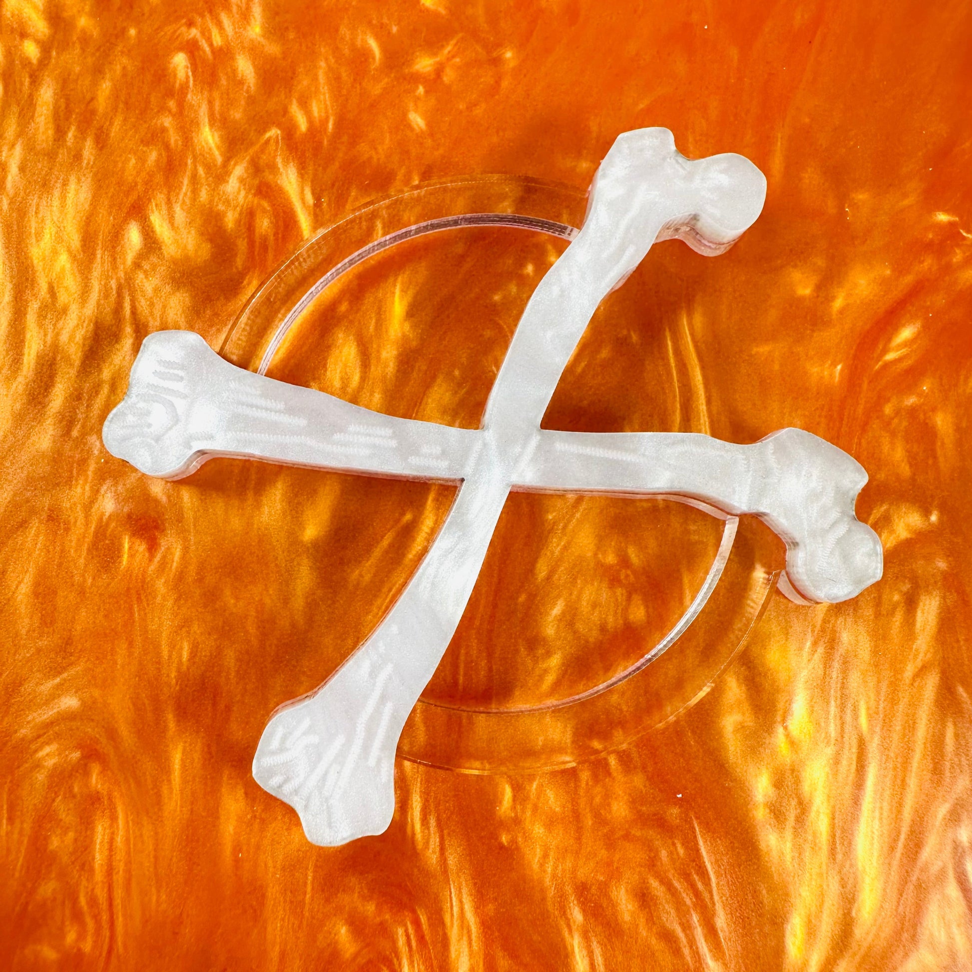 Clear glass with white bone-shaped decorations on an orange background
