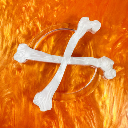 Clear glass with white bone-shaped decorations on an orange background
