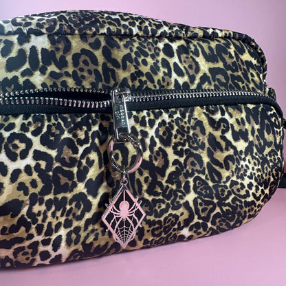Leopard print pouch with a key on a pink background