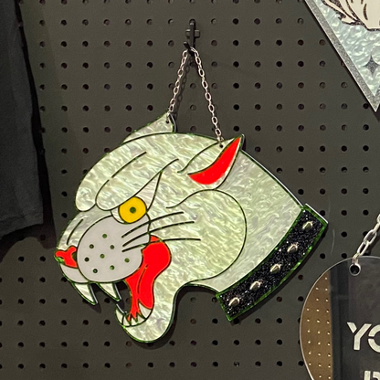 Decorative wall art featuring a stylized cat with red accents on a pegboard.