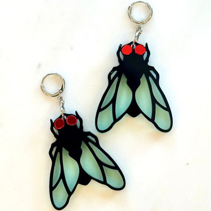 Pair of insect-shaped earrings with red eyes on a white background