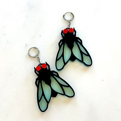 Pair of fly-shaped earrings on a white background