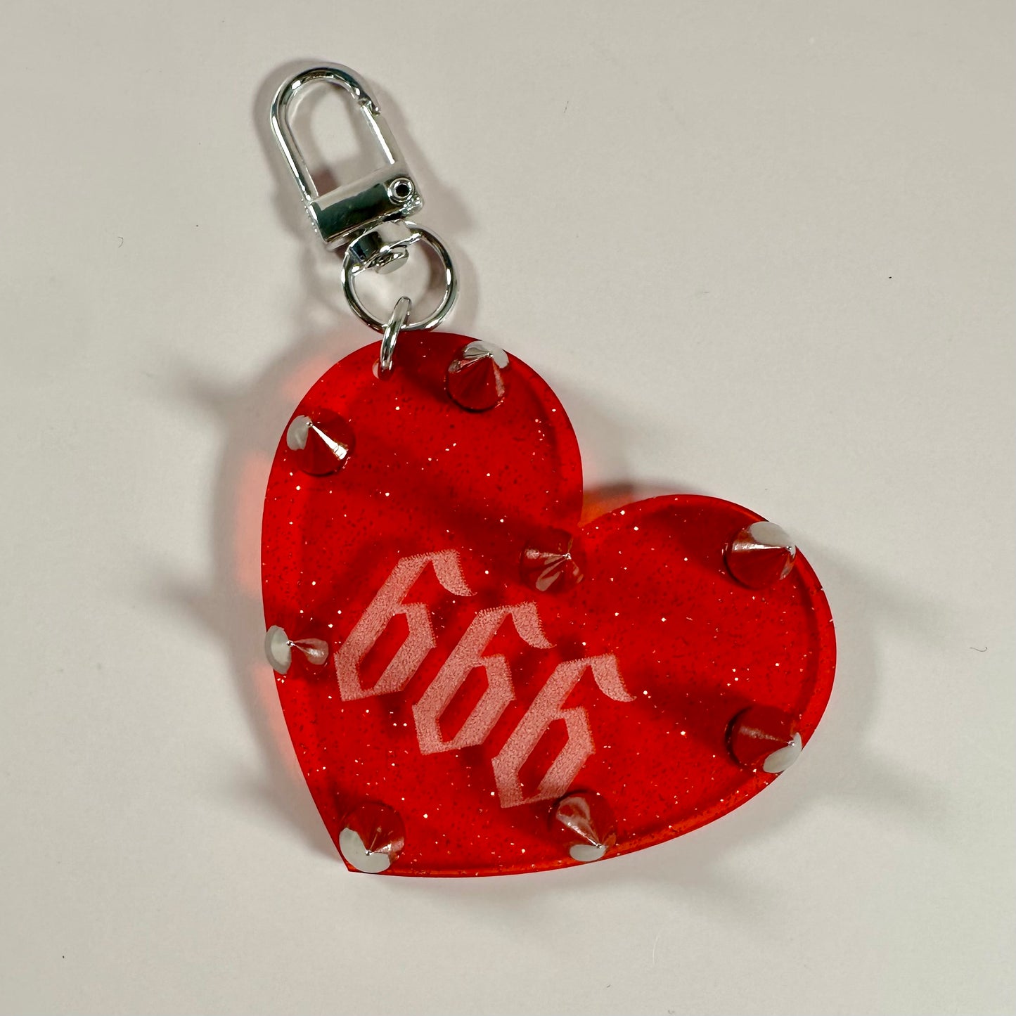 Red heart-shaped keychain with '696' design on a white background
