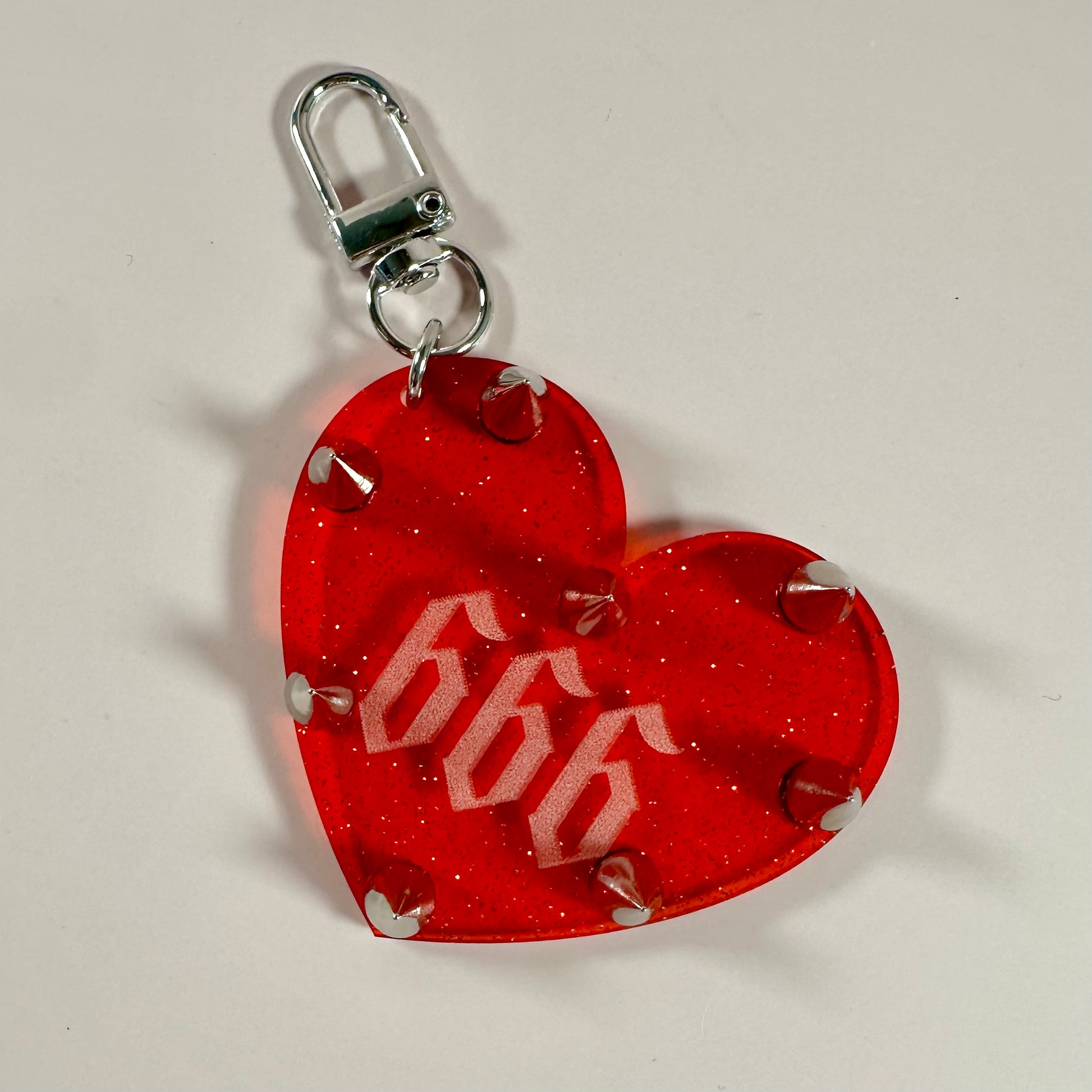 Red heart-shaped keychain with '696' design on a white background