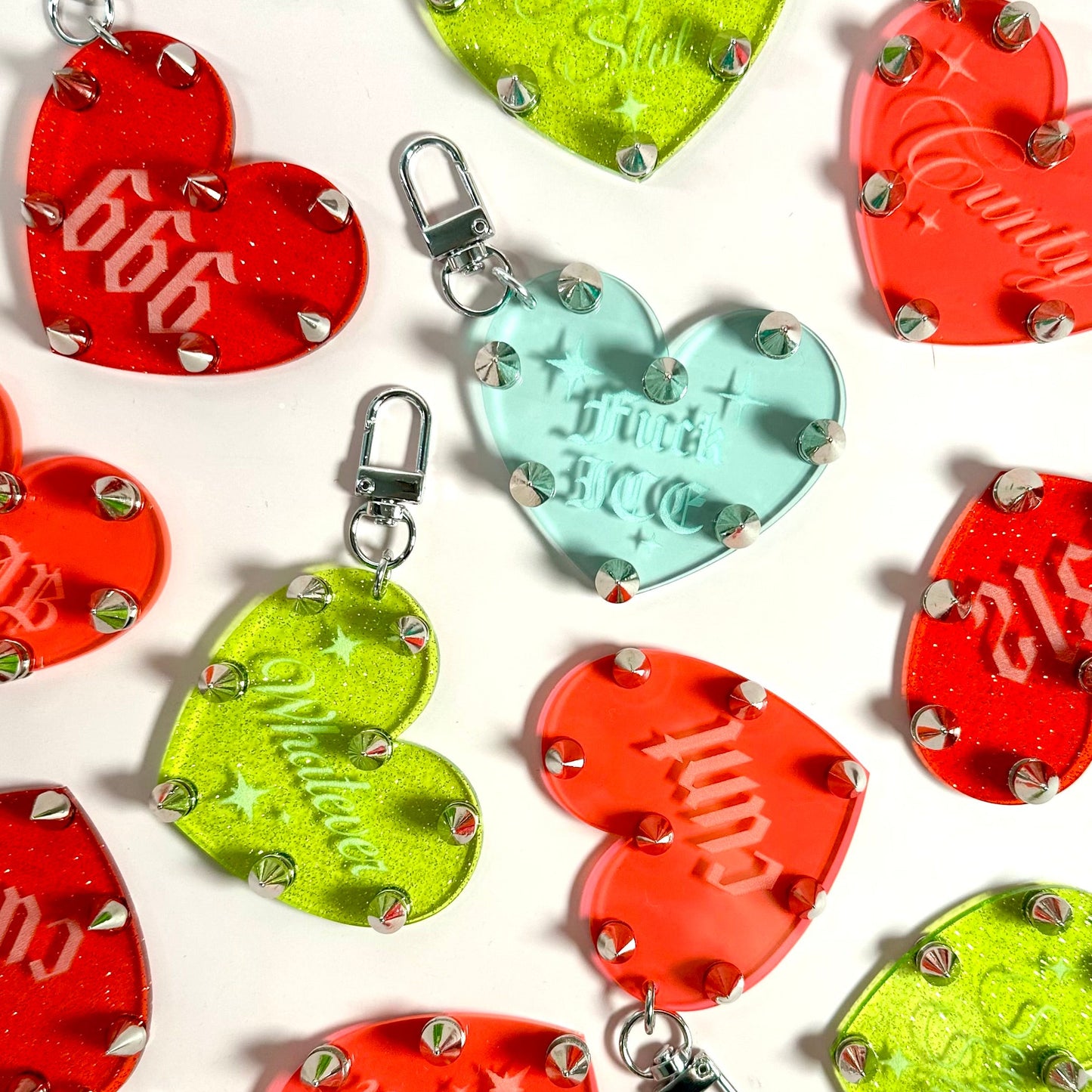 Colorful heart-shaped keychains with metallic accents on a white background