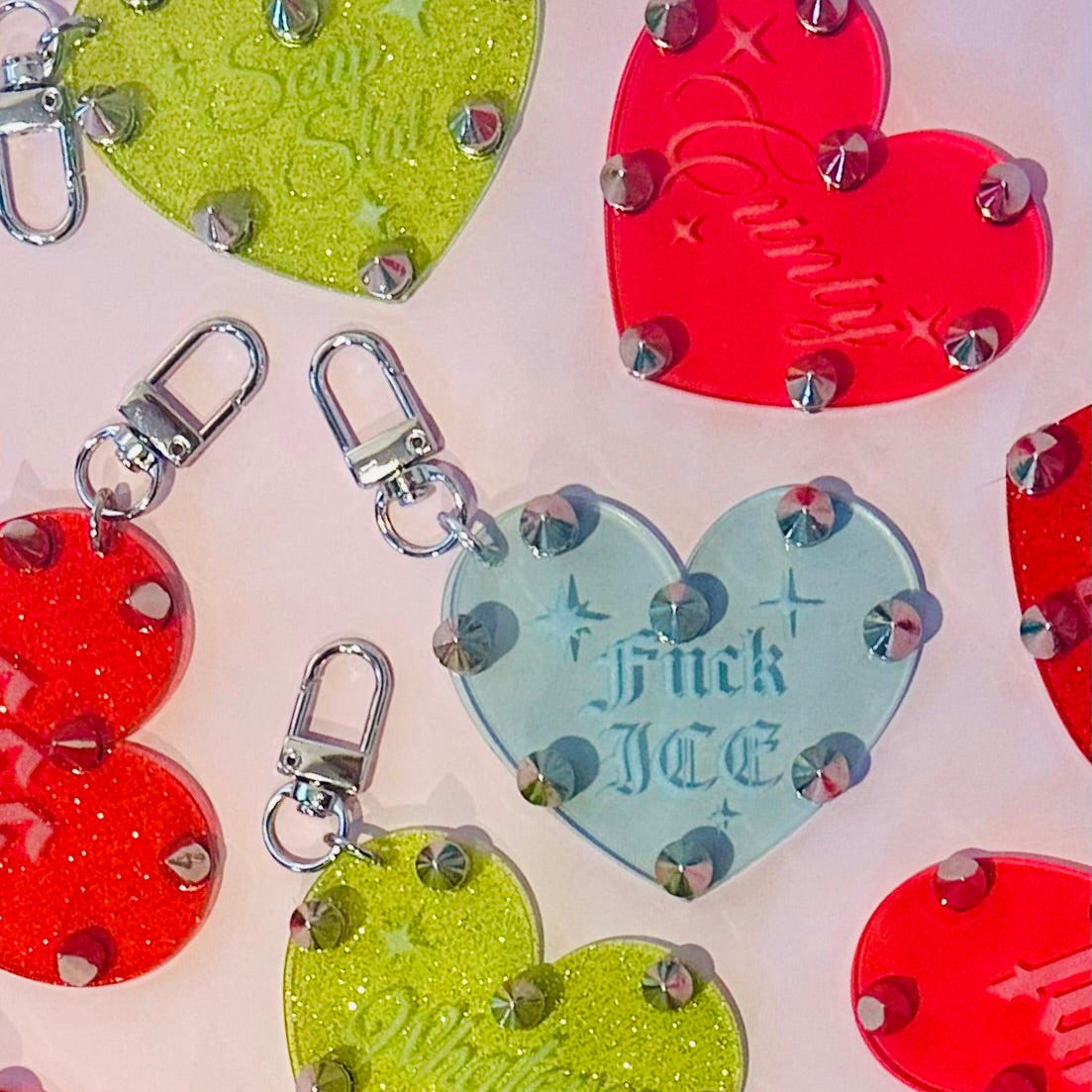 Colorful heart-shaped keychains with glittery accents on a light background