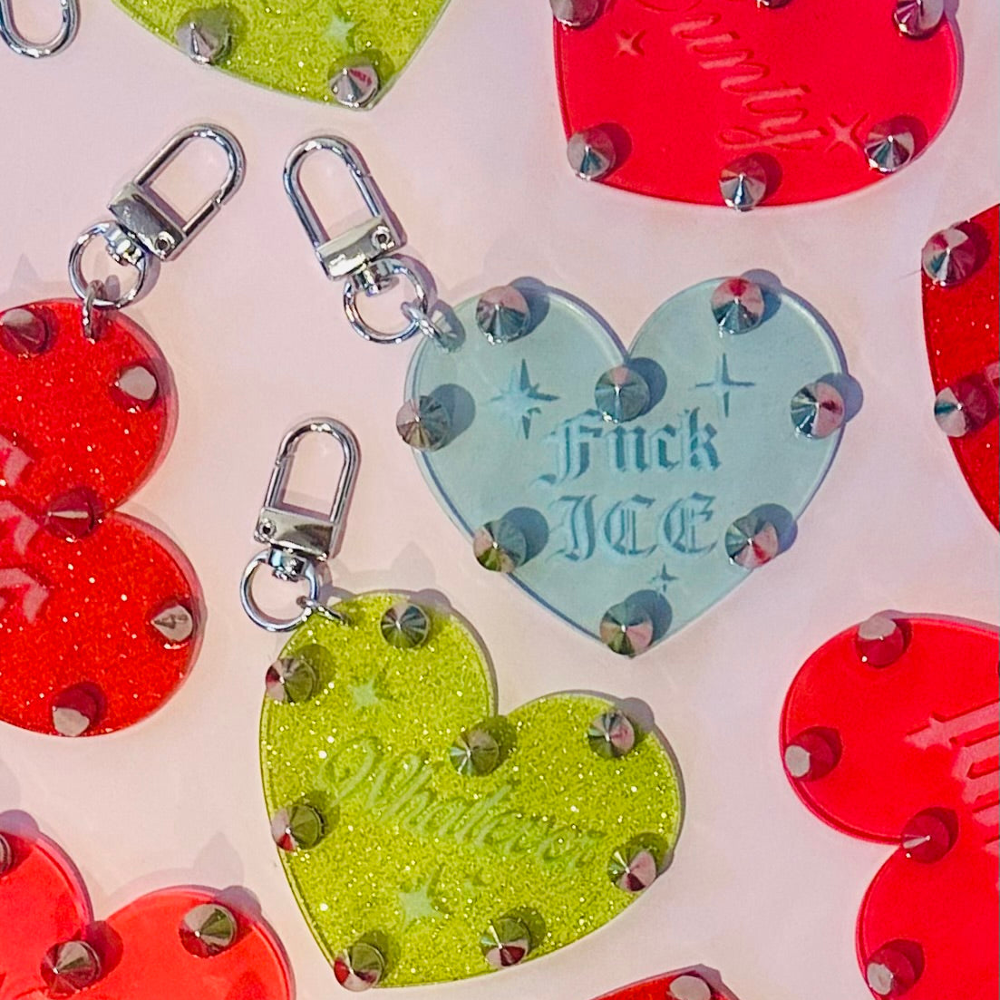Colorful heart-shaped keychains with glittery accents on a light background