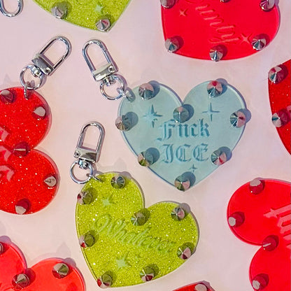 Colorful heart-shaped keychains with glittery accents on a light background