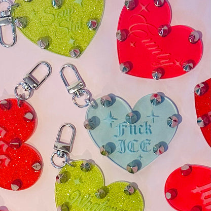 Colorful heart-shaped keychains with glittery accents on a light background