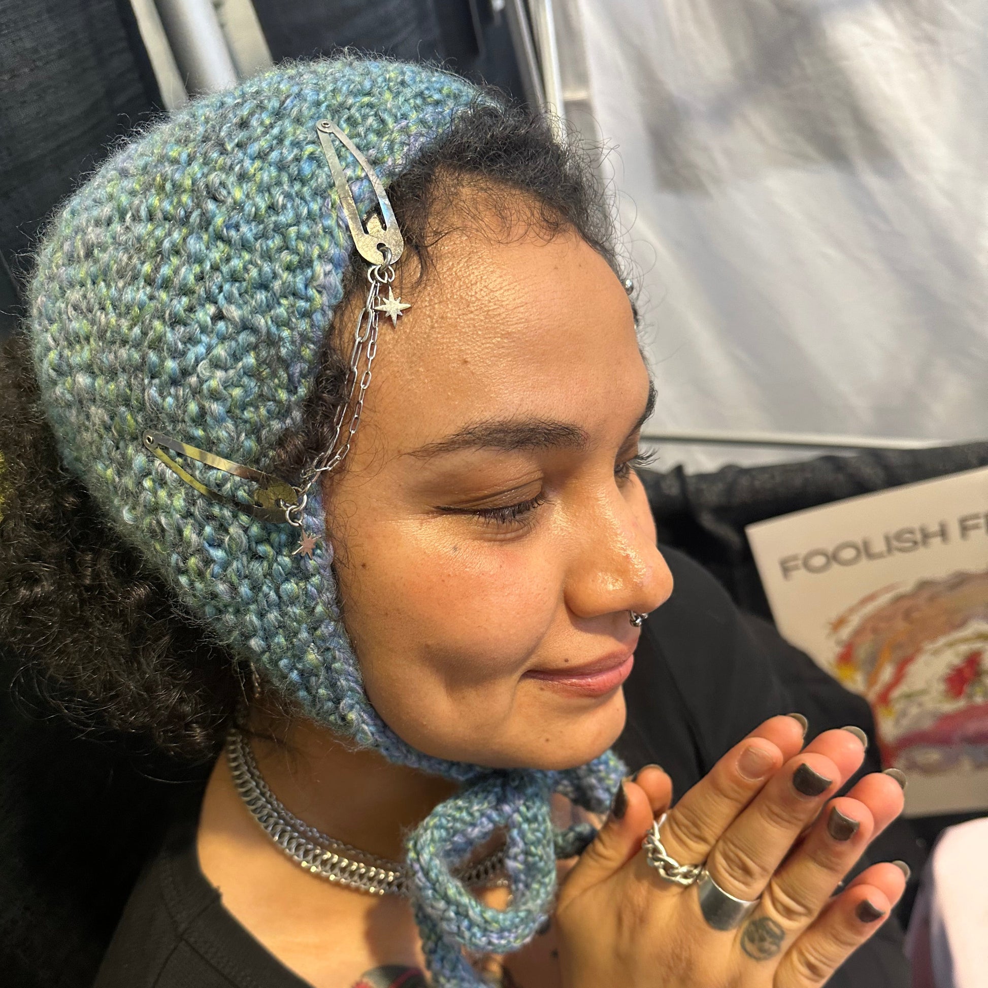 Person wearing a knitted headband with decorative elements, sitting in a car.
