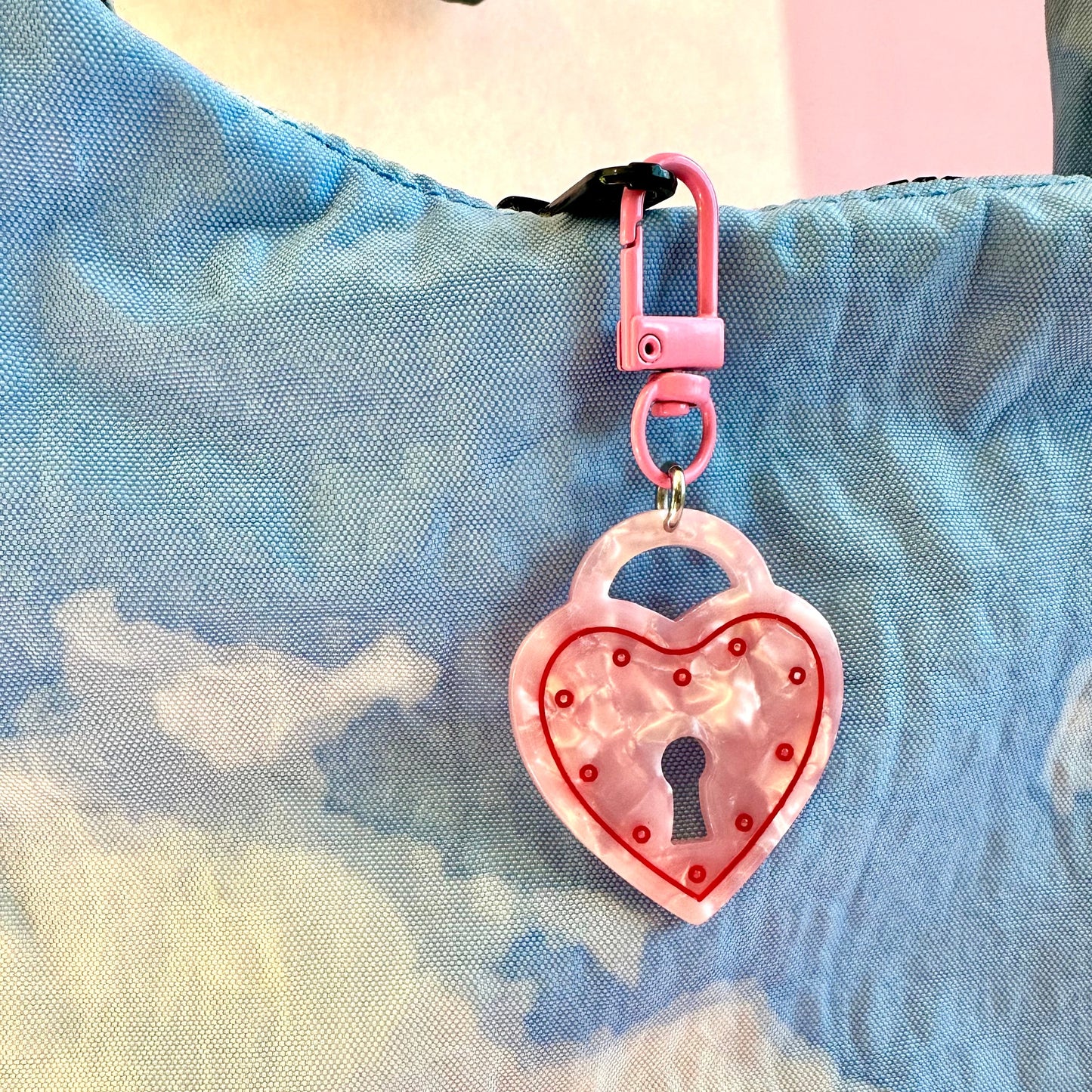 Heart-shaped keychain with lock design on a colorful background