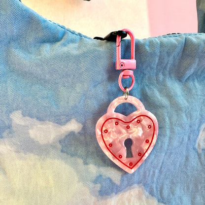 Heart-shaped keychain with lock design on a colorful background