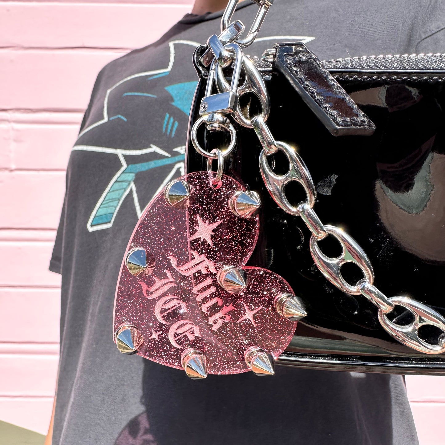 Heart-shaped keychain with 'Flick ICE' text on a black surface