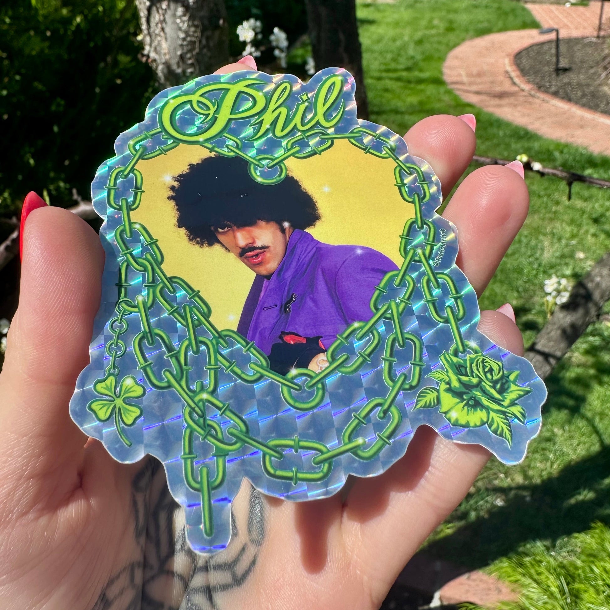 Sticker of a person with afro and mustache in a decorative frame held outdoors.