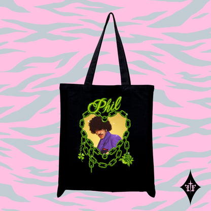 Black tote bag with a graphic design of a person in a purple shirt and text 'Phil' on a pink and blue patterned background.