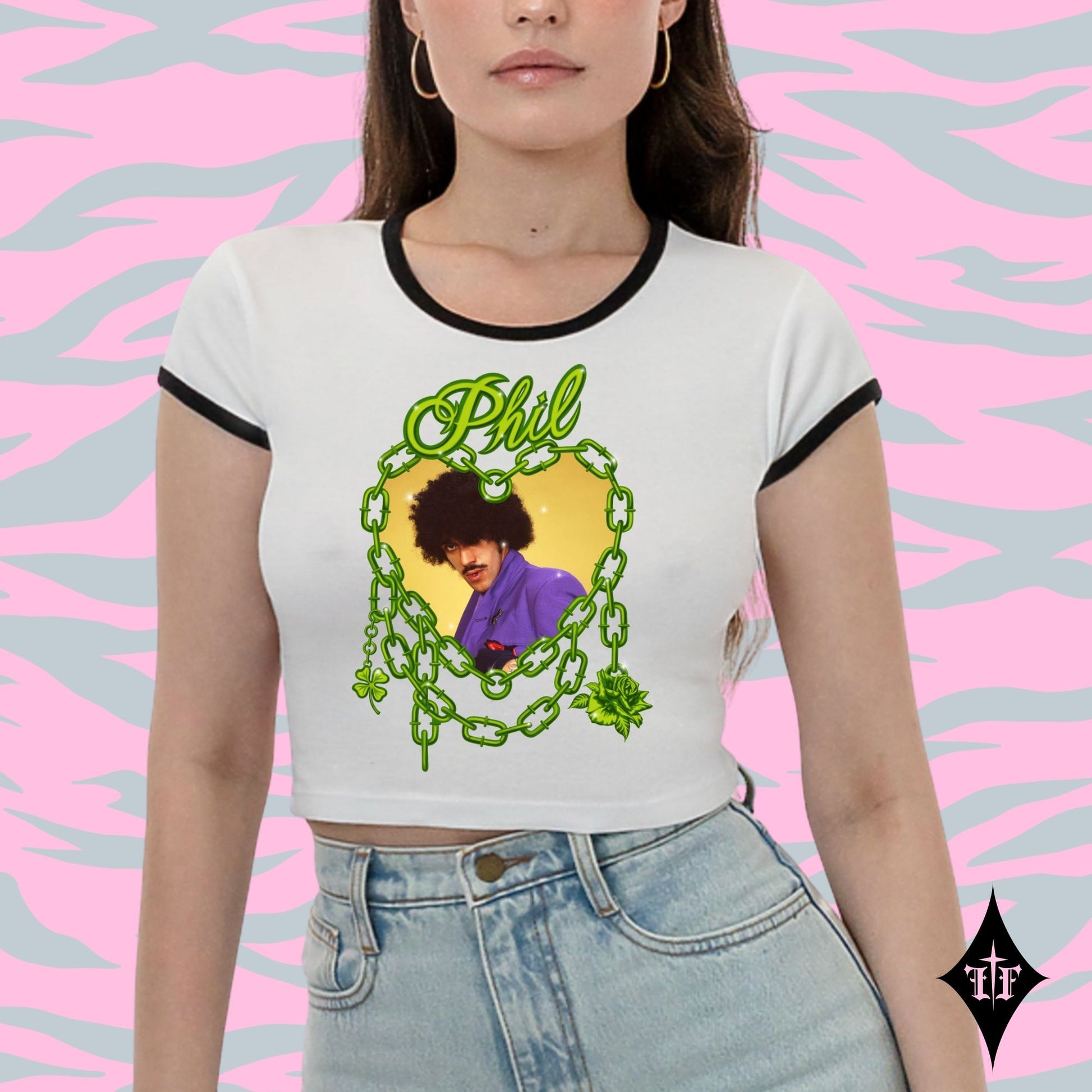 Person wearing a white t-shirt with a graphic design and text, standing against a pink and gray patterned background.