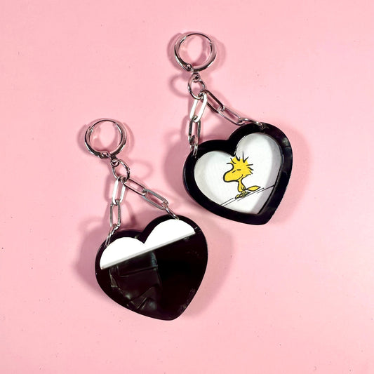 Heart-shaped keychains with cartoon character on a pink background