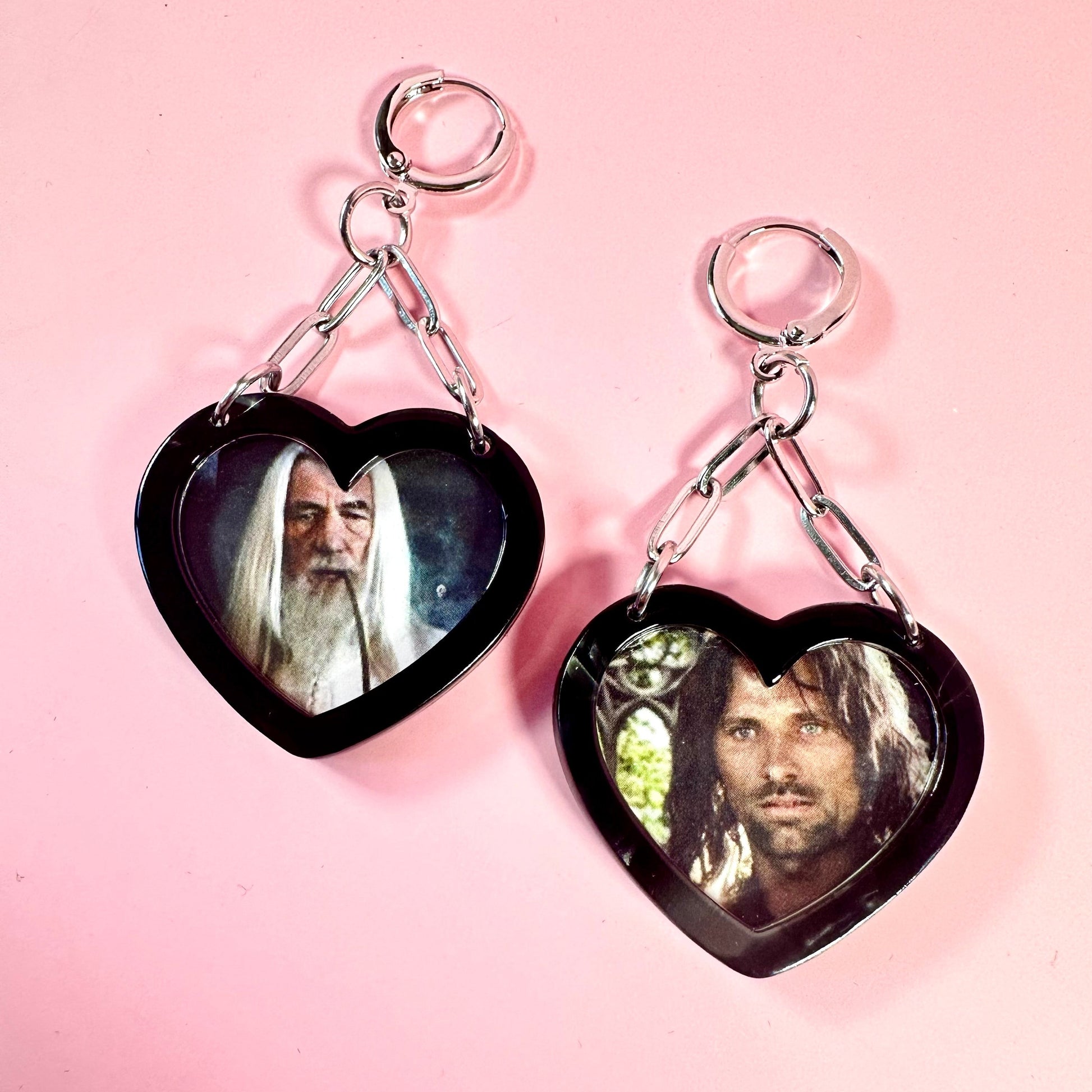 Heart-shaped earrings with images of characters on a pink background