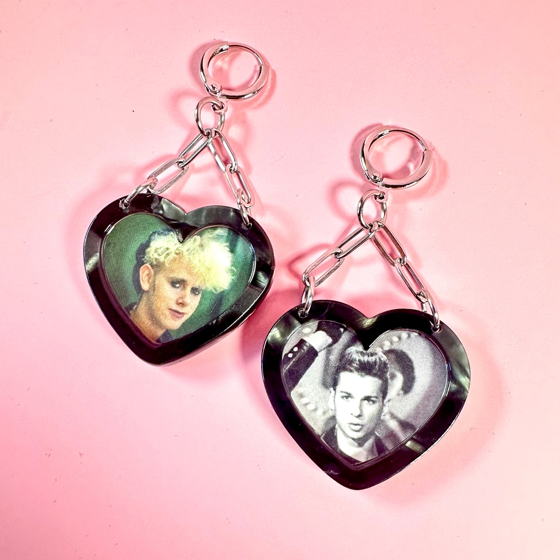 Heart-shaped keychains with images of people on a pink background