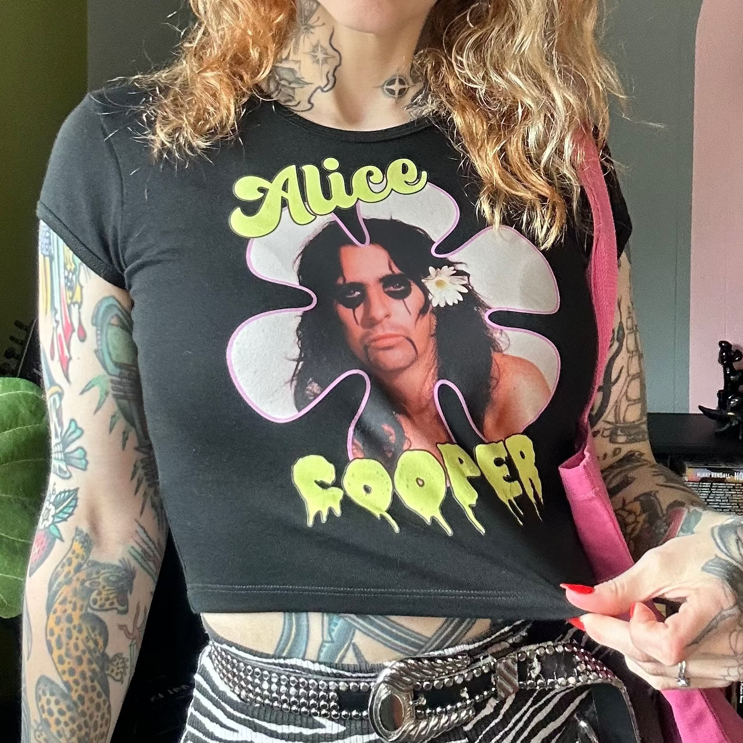 Person wearing a black t-shirt with 'Alice Cooper' design